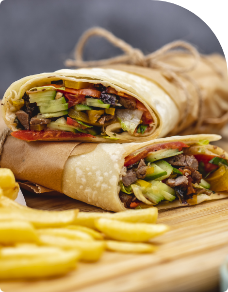 close-up-beef-burrito-with-tomato-cucumber-lettuce-jalapeno-served-with-fries-sauces